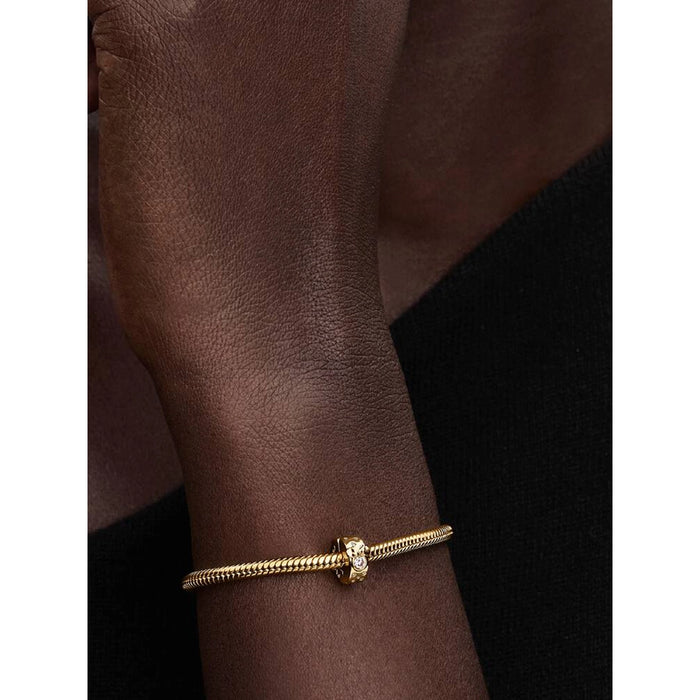 Gold Pandora bracelet worn on wrist featuring the Pandora Disney Mickey & Minnie Mouse Clip Charm with sparkling cubic zirconia.