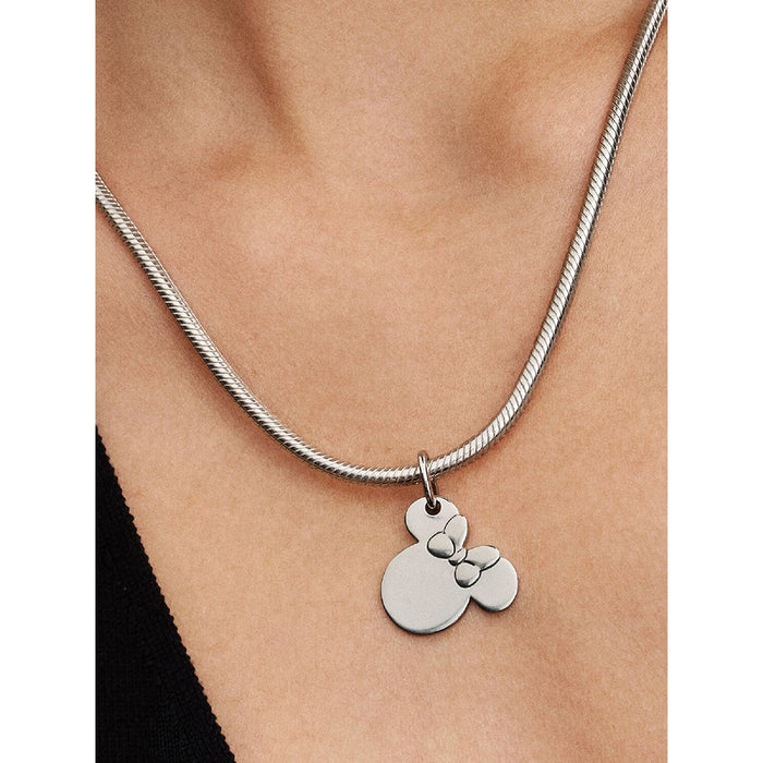 Model wearing the Pandora Disney Minnie Mouse Dangle Charm on a silver necklace.