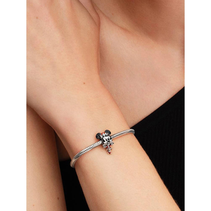 Close-up of a woman wearing a silver Pandora Moments bracelet featuring the Disney Minnie Mouse Holiday Charm.