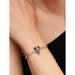 Close-up of a woman wearing a silver Pandora Moments bracelet featuring the Disney Minnie Mouse Holiday Charm.