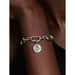 Woman wearing a silver charm bracelet with multiple medallion charms, including the Pandora Heart Medallion Charm.