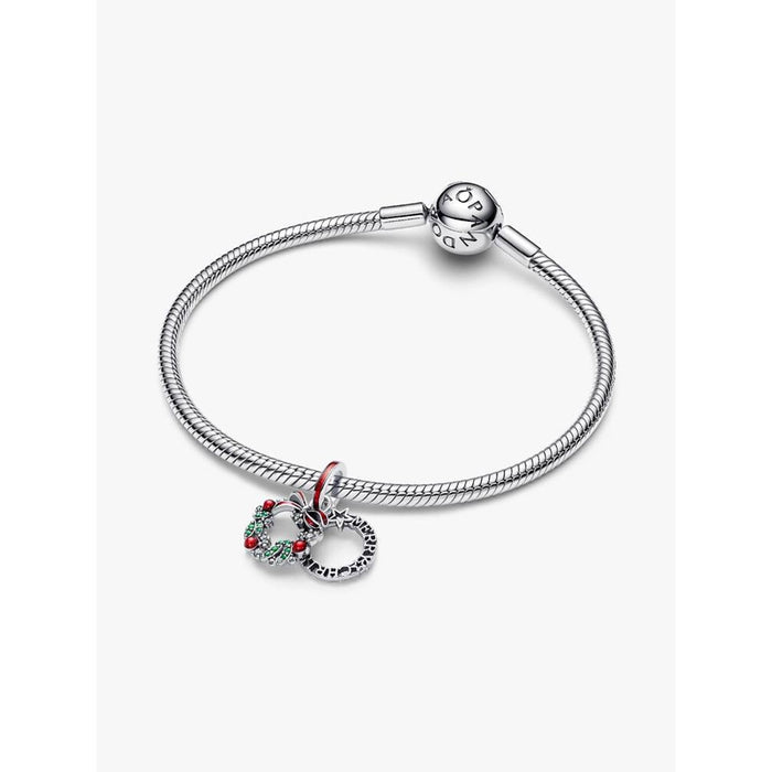 Pandora Holiday Wreath Double Dangle Charm styled on a silver Pandora Moments bracelet on a white background.