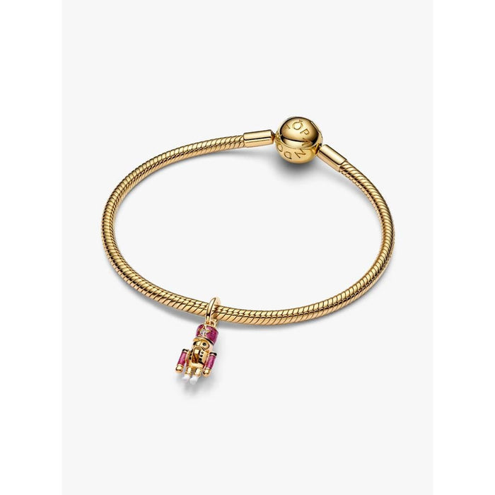 Gold Pandora bracelet featuring the Moveable Nutcracker Dangle Charm with pink enamel detailing.