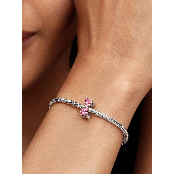 Model wearing a Pandora bracelet with the Pink Bow Charm displayed on the wrist.