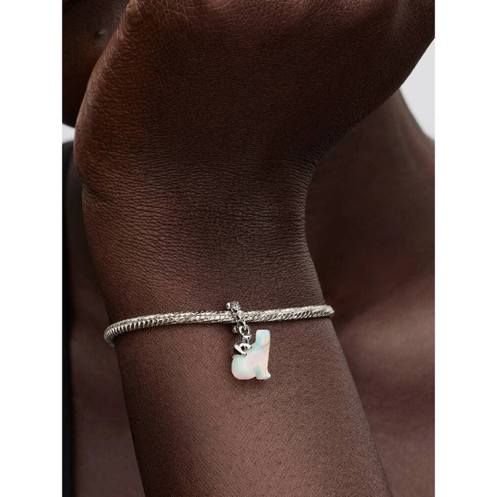 Polar Bear Mother & Cub Dangle Charm worn on a model’s wrist, highlighting the opal-inspired shimmer and sterling-silver cub detail.