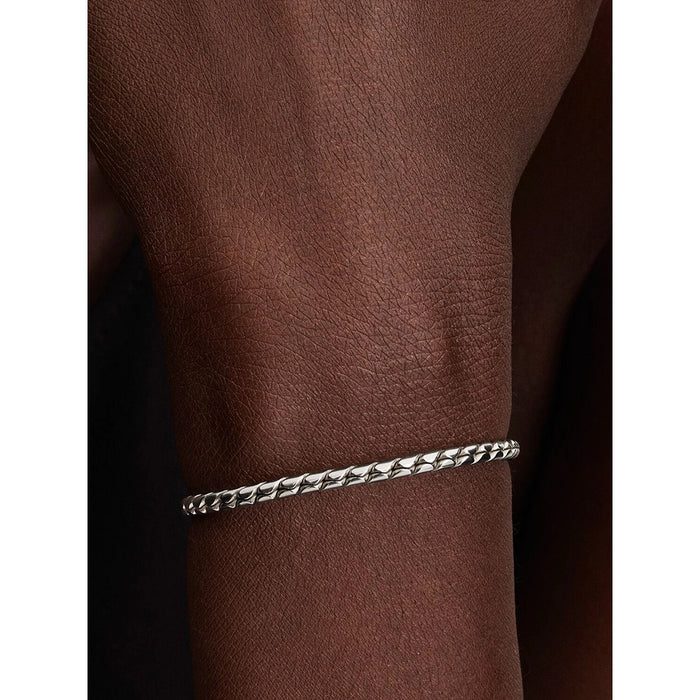 Close-up of Pandora sterling silver woven bracelet with clasp, minimal design.
