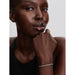 Woman wearing Pandora silver woven bracelet with sleek round clasp, styled with black top.