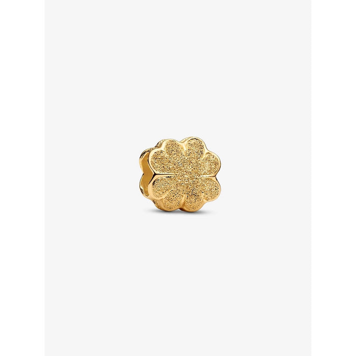 A close-up of a textured gold-plated four-leaf clover charm with sparkling detail.