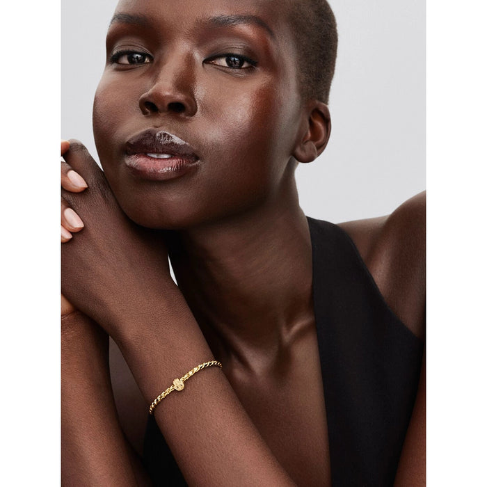Model wearing a gold bracelet styled with the Hamsa Hand charm, symbolizing strength and protection.