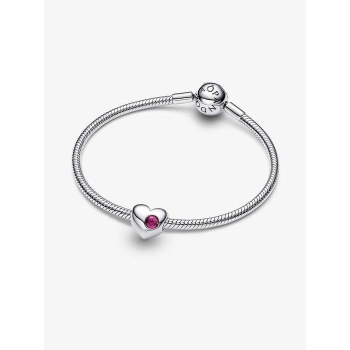 Pandora silver bracelet displayed on a white background, showcasing a heart-shaped charm with a red stone at the center.