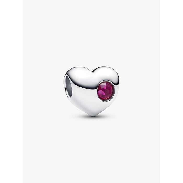 Pandora heart-shaped silver charm with a deep red faceted stone set on one side, shown on a white background.
