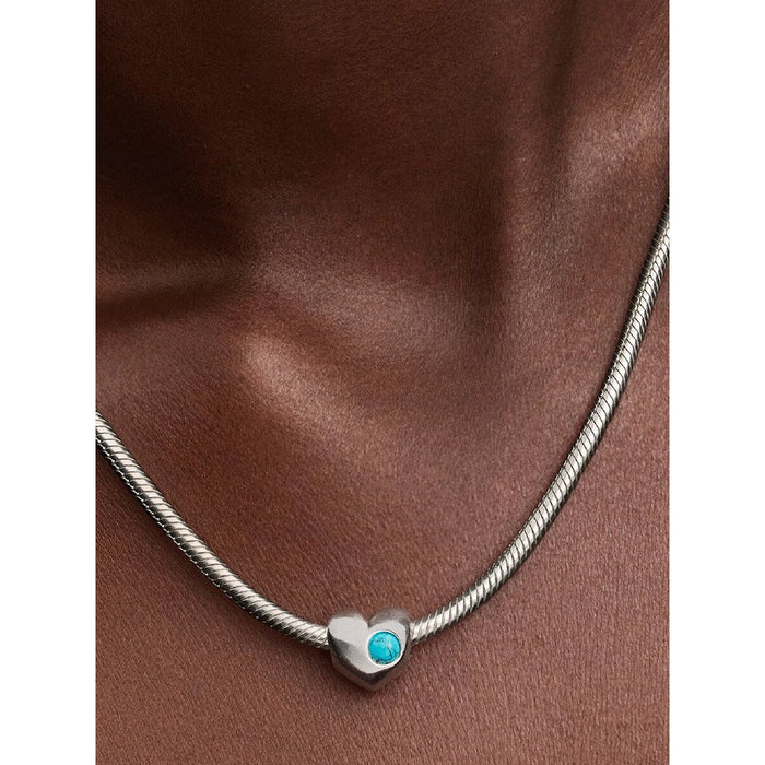 Model wearing PANDORA Turquoise Heart Charm on silver necklace.