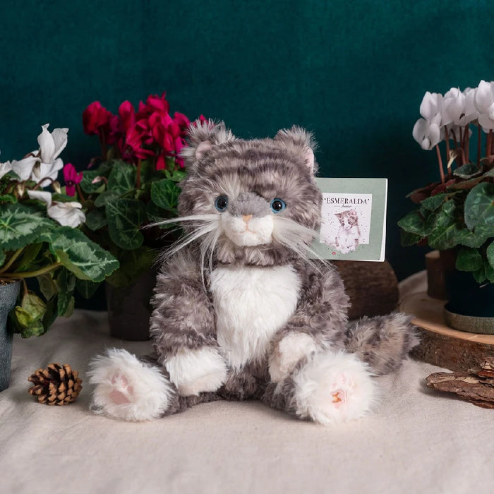 A soft, plush cat sits on a white backdrop, emphasizing its adorable design and cuddly appearance.