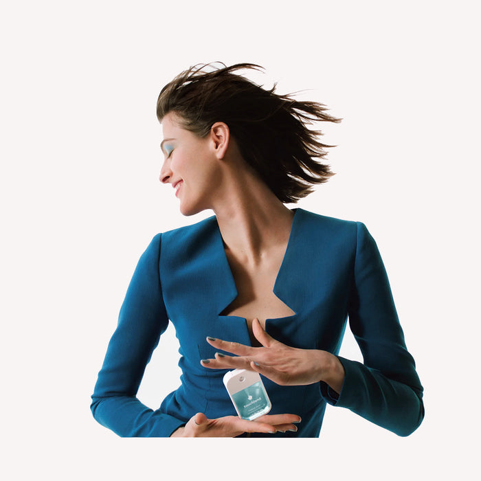 Woman in a blue jacket holding a small container against a white background