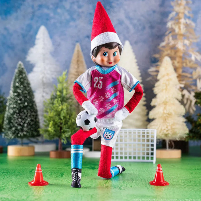 Elf on the Shelf in sports gear with a soccer ball and cones on a Christmas-themed background