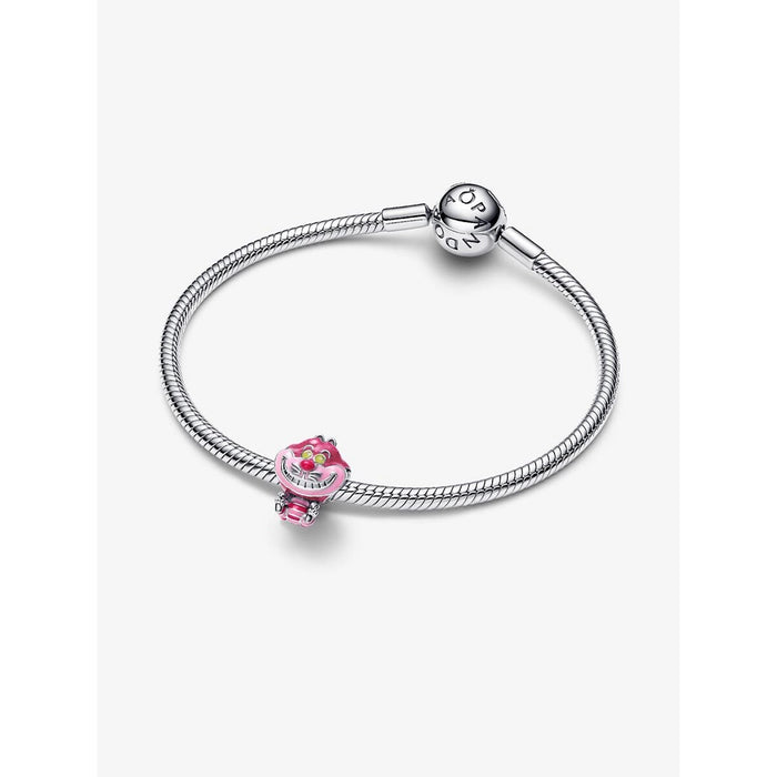 Silver Pandora bracelet with the Disney Cheshire Cat Charm attached, styled on a wrist. The charm shows the Cheshire Cat in bright pink enamel with a glitter finish.