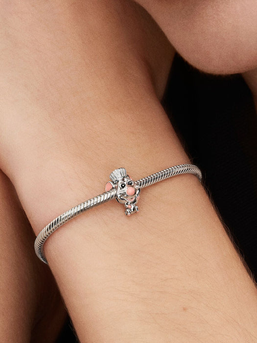 A silver bracelet featuring the Pandora Disney Pixar Ratatouille Remy Charm, shaped like Remy the rat wearing a chef’s hat, with pink enamel nose, ears, and tail.