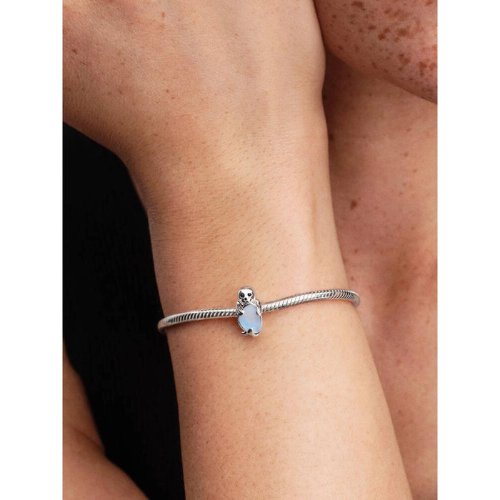 Model wearing a sterling silver Pandora bracelet featuring the blue crystal Seal Charm on the wrist.