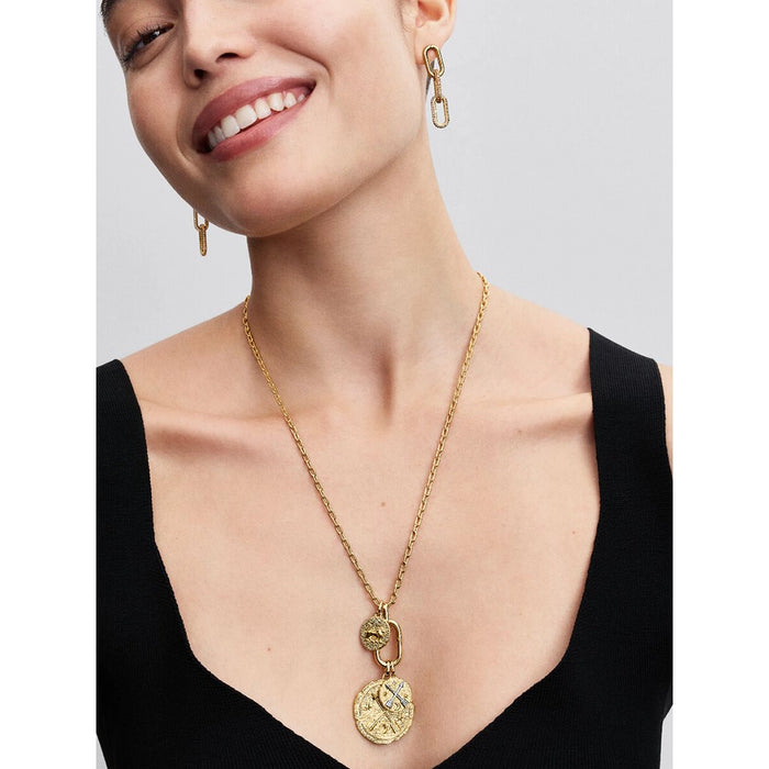 Smiling woman wearing a gold chain necklace with the Pandora Crossing Arrows Medallion Charm layered with other medallion charms, paired with gold link earrings.