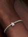 Sterling silver bracelet with a textured star-shaped charm shown on a model’s wrist.