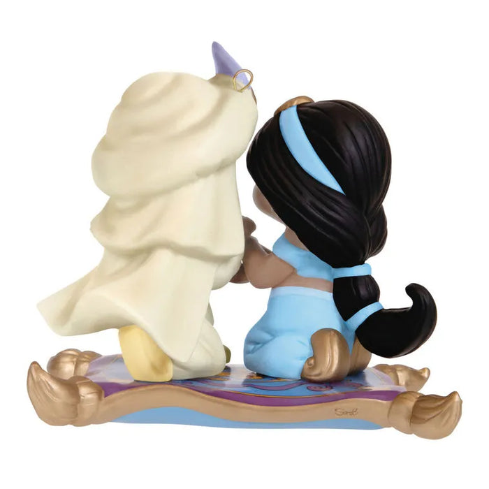 Back view of Hallmark 2026 Aladdin Jasmine porcelain ornament showing cream robe, purple turban, and Sant signature on magic carpet