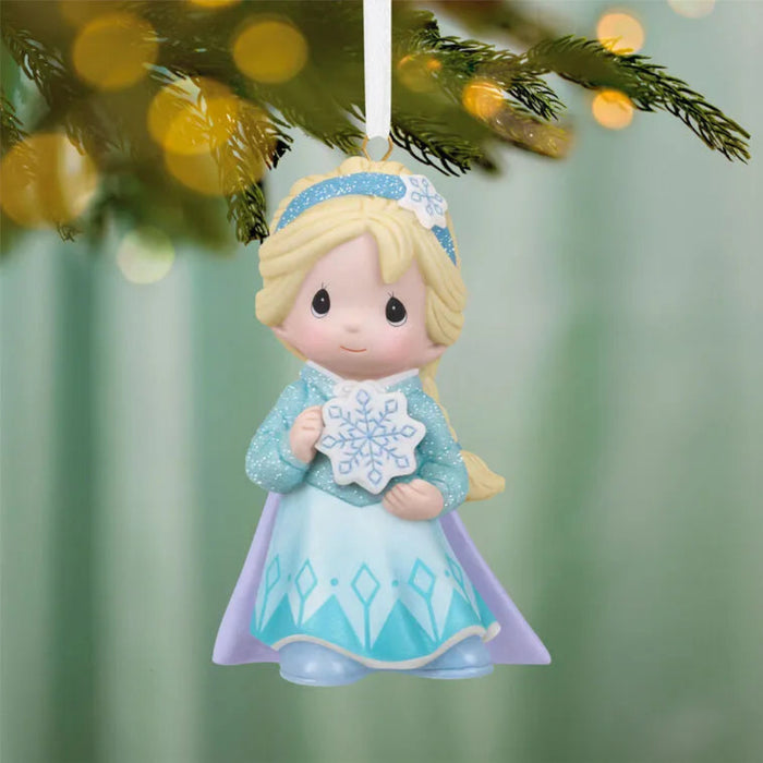 Hallmark 2026 Frozen Elsa porcelain ornament with glittery ice-blue gown and lavender cape hanging on pine branch
