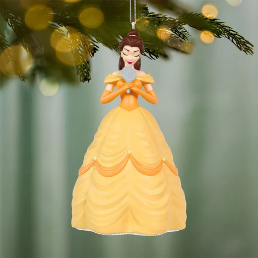 Belle Disney ornament suspended on pine branch with golden bokeh lights and festive background