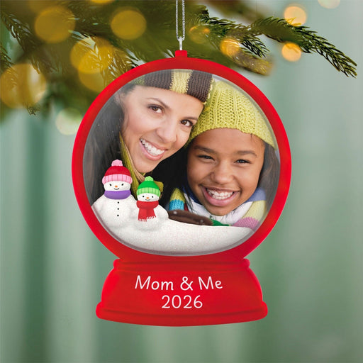 Red Hallmark Mom and Me 2026 snow globe ornament with photo frame and glitter snowmen on Christmas tree