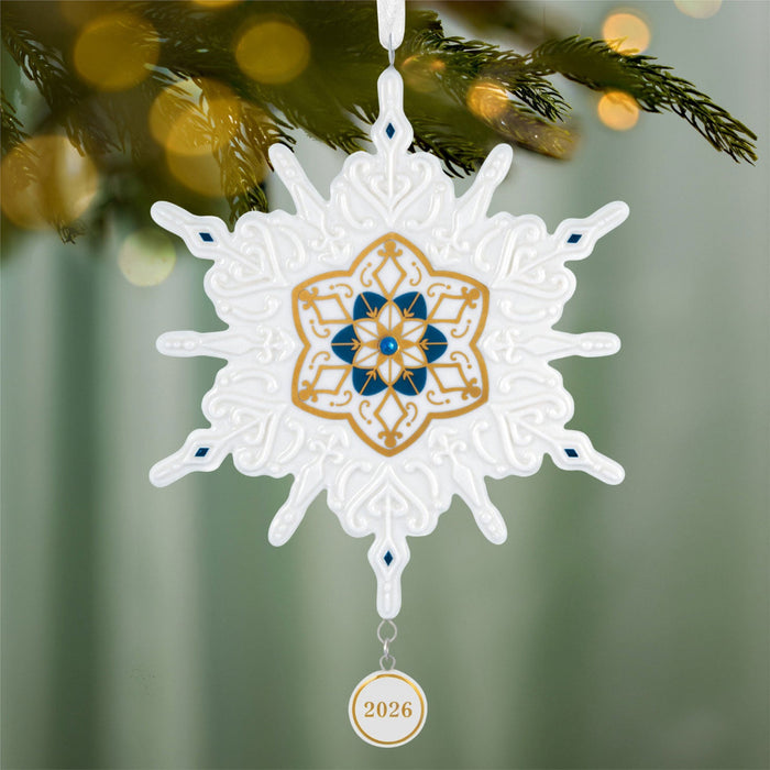 Decorative snowflake ornament with intricate design on a Christmas tree.