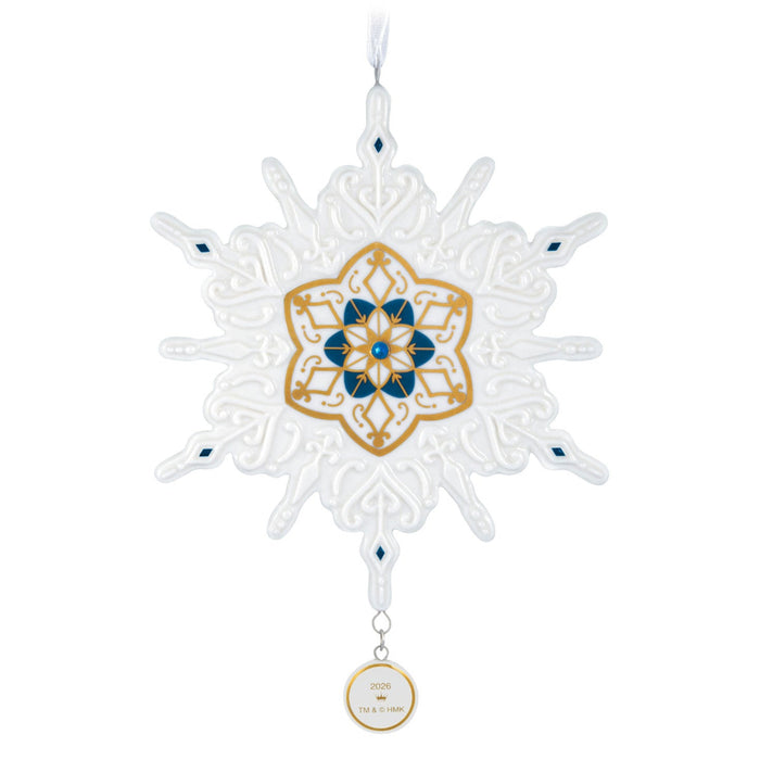 Decorative snowflake ornament with gold and blue center on a white background