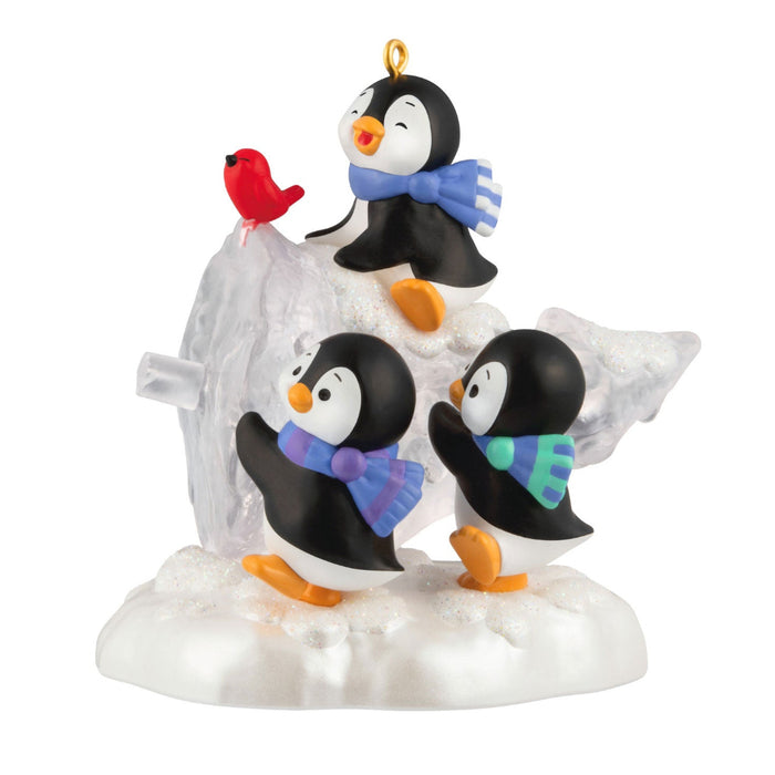Ornament with penguins and a bird on a snowy base