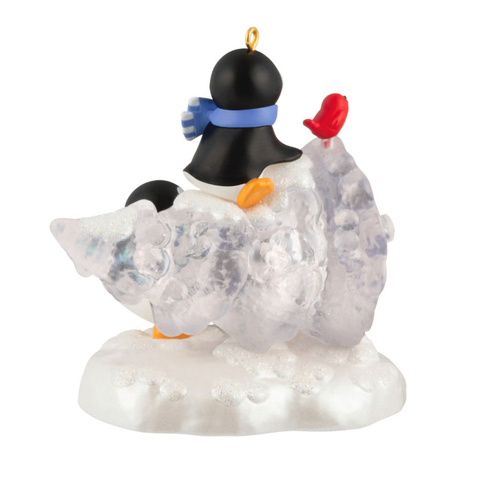 Penguin ornament with a blue scarf and red beak on a white background