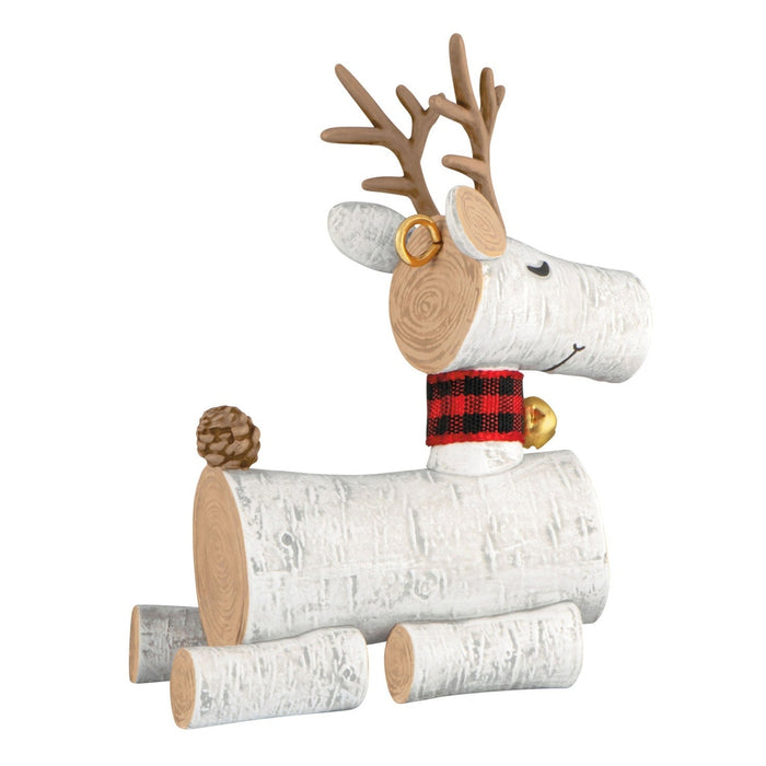 Rear profile of white birch bark texture reindeer ornament with red plaid scarf and pinecone tail on white background