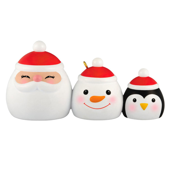 Three Christmas-themed figurines: Santa, snowman, and penguin, on a white background.