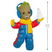 Toy figure of a character in a blue snowsuit with a snowball, wearing headphones, on a white background.