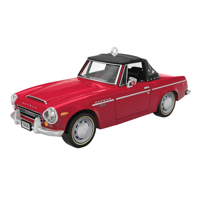 Three-quarter view of cherry red 1968 Datsun 2000 Sports ornament showing white pinstripe and chrome details