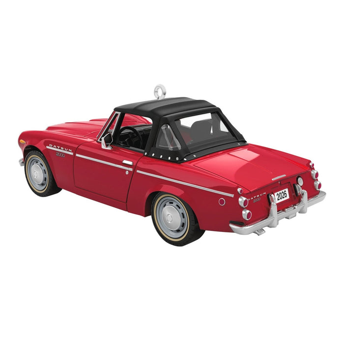 Rear view of red Datsun 2000 Sports ornament highlighting dual tailfins, round taillights, and 2026 license plate