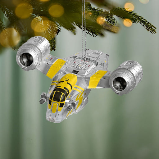 Star Wars Razor Crest Christmas ornament hanging on pine branch with golden bokeh lights and detailed engine nacelles