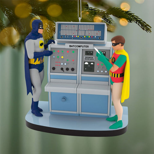 Batman Batcomputer Christmas ornament hanging on tree branch with warm bokeh lights highlighting glossy finish