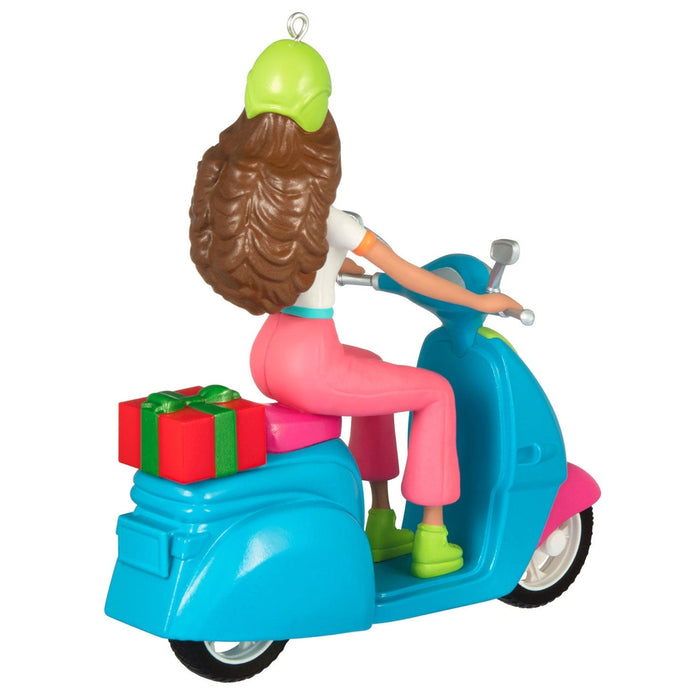 Rear view of 2026 Barbie keepsake ornament showing wavy brown hair and scooter rear wheel details