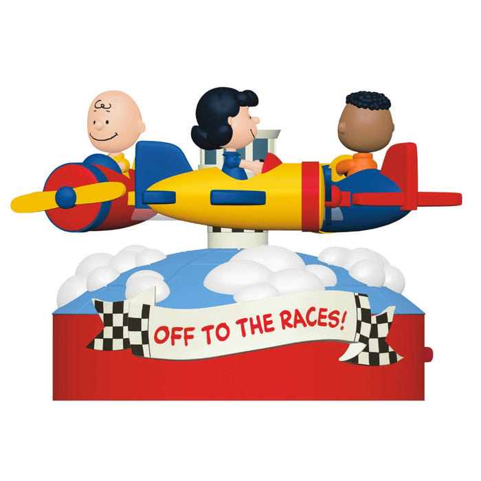 Toy set with three characters on a race car, featuring a banner 'Off to the Races!' on a white background.