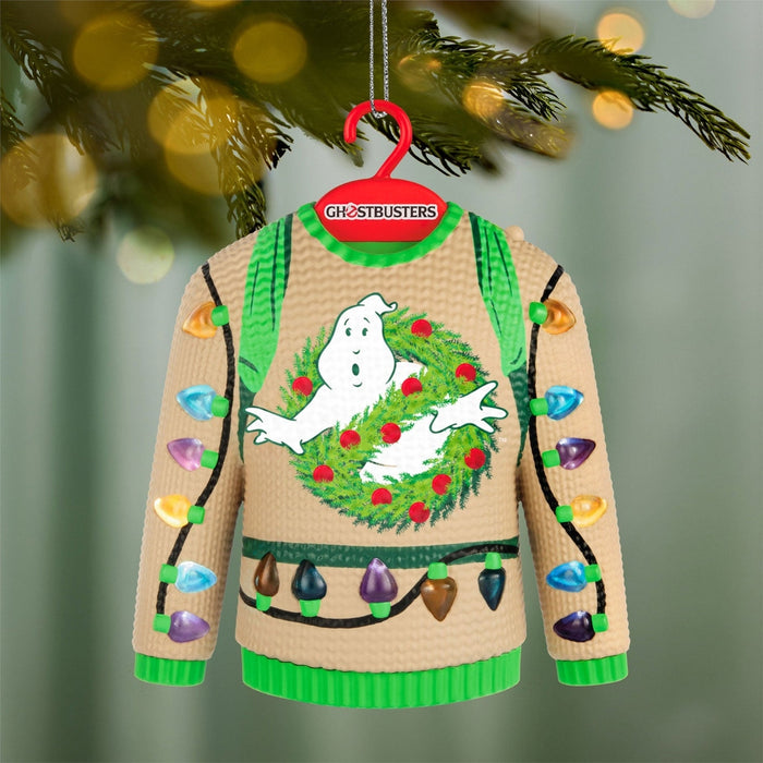 Ghostbusters light-up sweater ornament against blurred pine branches with bokeh lights