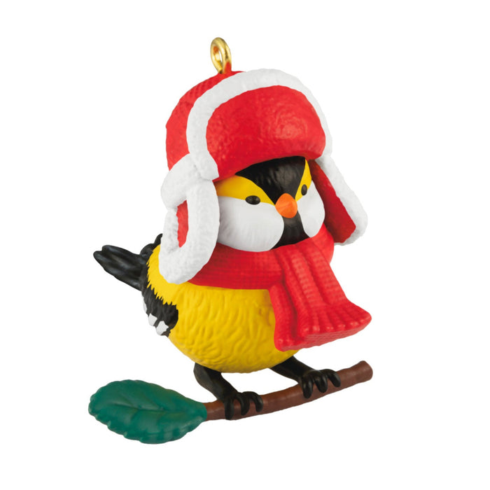 Christmas ornament of a bird wearing a red hat and scarf on a white background