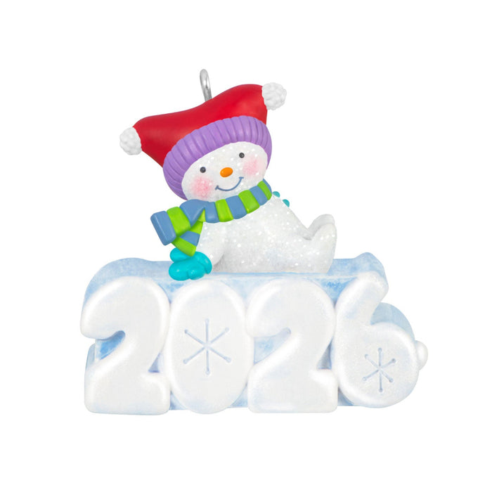 Decorative ornament with a snowman wearing a red hat and green scarf, sitting on the number '2021'.