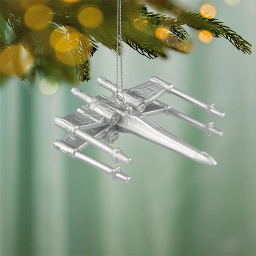  Starwars  Silver spaceship ornament hanging on a Christmas tree with blurred lights in the background