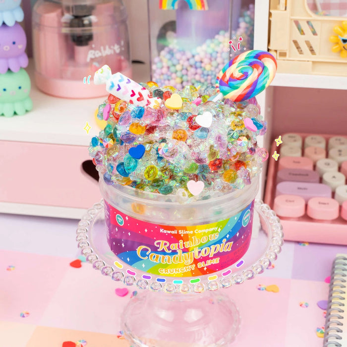 Colorful candy jar labeled 'Rainbow Candytopia' on a pink surface with pastel background