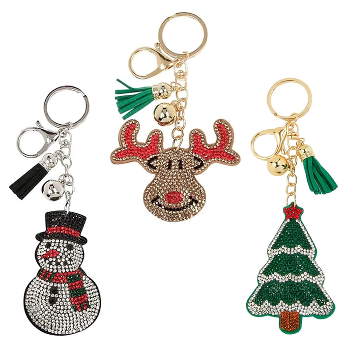 Three festive keychains shaped like a snowman, reindeer, and Christmas tree on a white background.