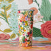 A tumbler with a lively floral design, displaying an assortment of colorful flowers and intricate details.