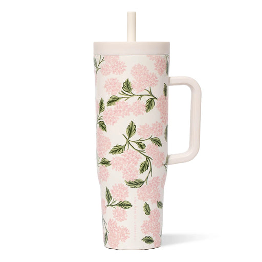 A pink and green floral print mug with a straw, featuring vibrant flowers against a light background.