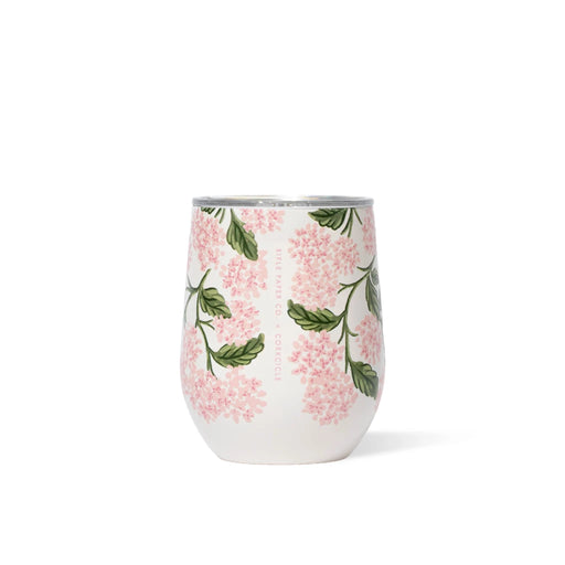 A wine glass filled with pink flowers and green leaves, elegantly arranged for a decorative display.